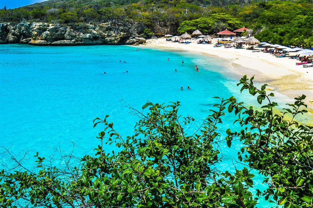 Curacao cove with a sandy beach and bright turquoise water