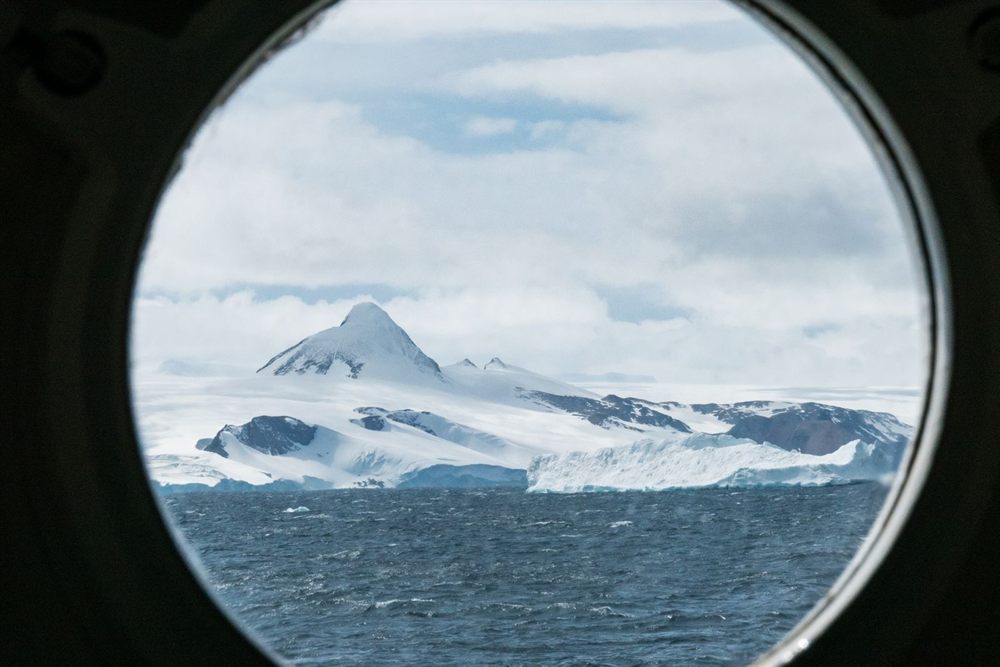Snowy polar mountains seen through a ship porthole